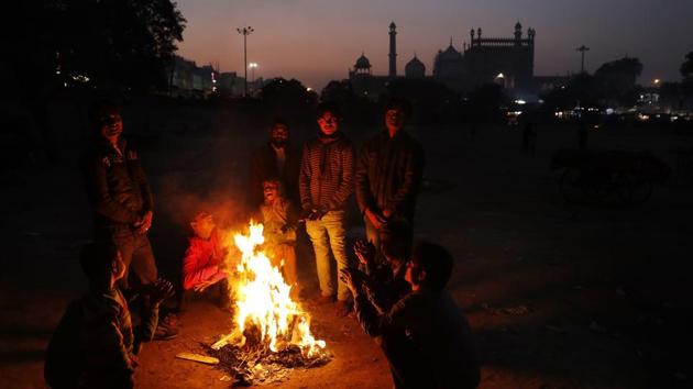 Farmaan (4th L), and other homeless and daily wage labourers keep themselves warm around a bonfire. More than 20 years ago, Ruby Khan and her husband, Nisar, came to New Delhi, hoping to find work and some sort of future in the capital. They were desperately poor and barely educated. (Altaf Qadri / AP) 