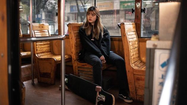 Mu sits with her board on a bus. Bigger and easier to manoeuver than a skateboard, longboarders say it allows for a smoother and more comfortable ride, many using it in their daily commutes. (Fred Dufour / AFP) Mu sits with her board on a bus. Bigger and easier to manoeuver than a skateboard, longboarders say it allows for a smoother and more comfortable ride, many using it in their daily commutes. (Fred Dufour / AFP)
