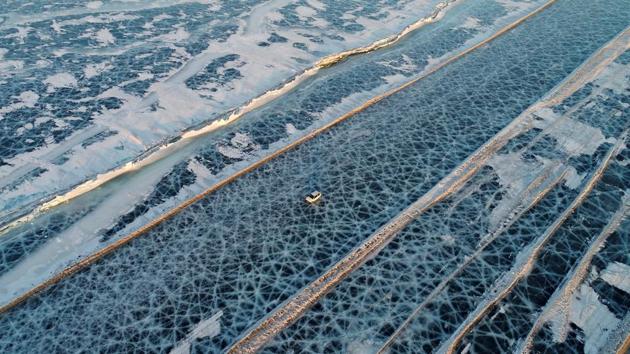 A car drives along a five-kilometre-long road, which is supervised by regional traffic services to connect the banks of the ice-covered Yenisei River during winter season, south of Krasnoyarsk, Russia. (Ilya Naymushin / REUTERS) 