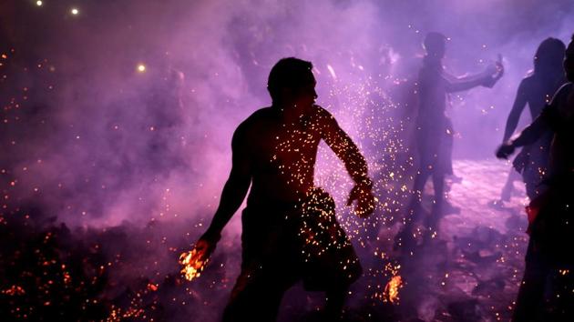 A Balinese man holds a burning coconut shell during Mesabetan Api, a purification ritual to enter the holy day of Nyepi, which is a day of silence for self-reflection to celebrate the Balinese Hindu New Year, in Gianyar, Bali, Indonesia. (Johannes P. Christo / REUTERS) 