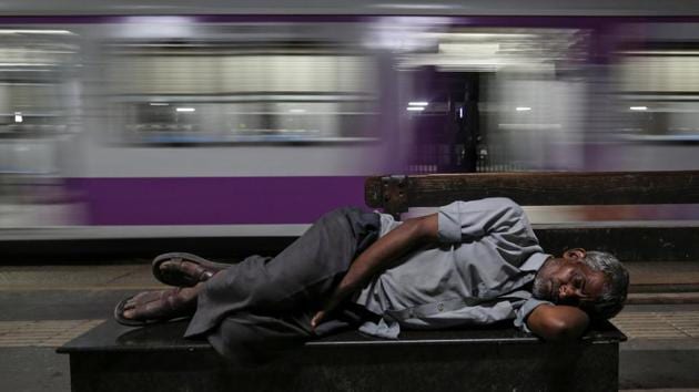 A man sleeps on a bench next to a passing train at a railway station in Mumbai, Maharashtra. (Francis Mascarenhas / REUTERS) A man sleeps on a bench next to a passing train at a railway station in Mumbai, Maharashtra. (Francis Mascarenhas / REUTERS)