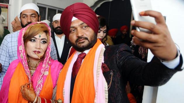 Groom Parvinder Singh taking selfie with his wife (Pakistan national) Kiran Sarjeet Kaur after their marriage ceremony at Gurdwara Khel Sahib in Patiala on Saturday.(HT Photo)