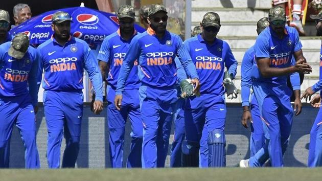 Cricket - India v Australia - Third One-Day International - Jharkhand State Cricket Association Stadium, Ranchi, India - March 8, 2019 - India's captain Virat Kohli (C) and his teammates wearing army camouflage-style caps walk onto the field. REUTERS/Stringer(REUTERS)