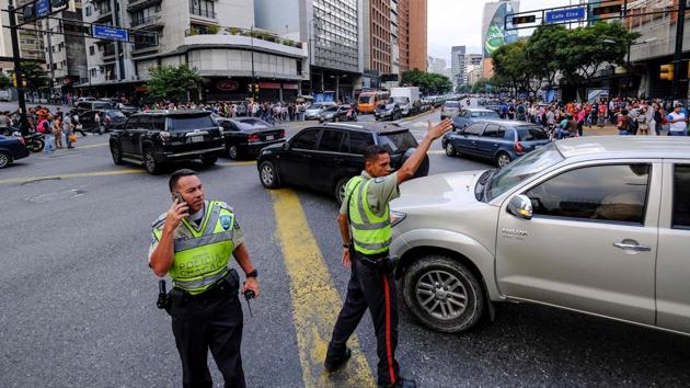 Traffic policemen direct traffic at an intersection during the power cut in Caracas. Power was gradually being restored to large areas of Caracas on Friday afternoon, as well as parts of Miranda state and Vargas, which contains the country’s international airport. (Matias Delacroix / AFP) Traffic policemen direct traffic at an intersection during the power cut in Caracas. Power was gradually being restored to large areas of Caracas on Friday afternoon, as well as parts of Miranda state and Vargas, which contains the country’s international airport. (Matias Delacroix / AFP)