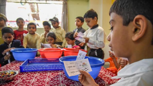 A student is seen reading the election ticket ballot, before casting vote. (Sanket Wankhade/HT PHOTO) 
