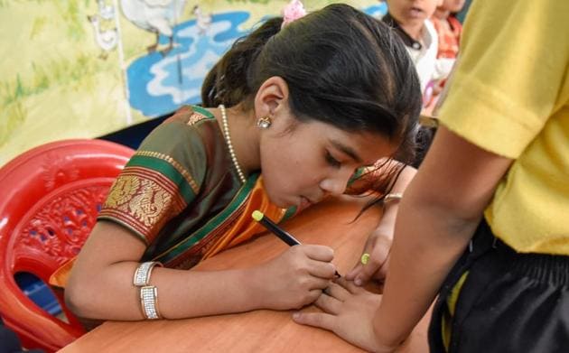 Post casting their vote, an official is seen marking the person for having casted their vote. (Sanket Wankhade/HT PHOTO) 