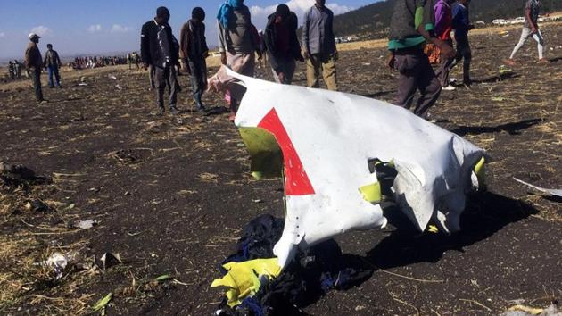 People walk past a part of the wreckage at the scene of the Ethiopian Airlines Flight ET 302 plane crash, near the town of Bishoftu, southeast of Addis Ababa, Ethiopia on March 10.(REUTERS)