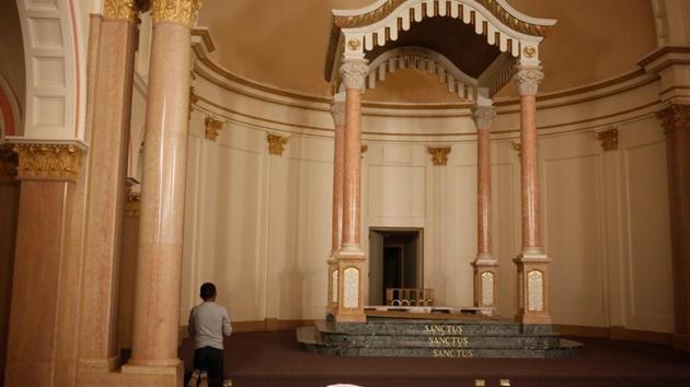 A Guatemalan migrant takes off his hat and prays in the chapel of a monastery. The monastery has housed more than 1,000 people since it was opened and these are unprecedented numbers for this time period and this region. (Nicole Neri / REUTERS)