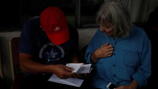 This man from Honduras, migrating with his son, checked his Greyhound ticket several times with volunteers before departing from a motel. The shelters in Arizona are way stations for migrants released by border agents that need a place to stay while they figure out where they can settle in the United States and pursue claims in immigration court. (Nicole Neri / REUTERS)