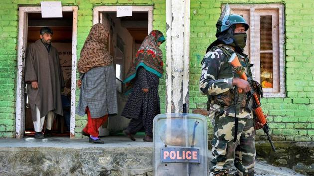 Ganderbal: Voters leave after casting their vote as security personnel stands guard at a polling station during the second phase of Panchayat elections at Kangan, in Gandrebal district, Tuesday, Nov. 20, 2018. ( PTI Photo/S Irfan)(PTI11_20_2018_000053B)(PTI)