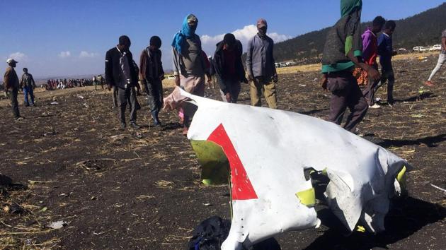 People walk past a part of the wreckage at the scene of the Ethiopian Airlines Flight ET 302 plane crash, near the town of Bishoftu, southeast of Addis Ababa, Ethiopia March 10, 2019.(REUTERS)