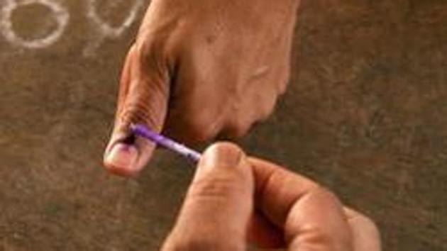A polling officer marks the finger of a voter with indelible ink at a polling station.(AP Photo)