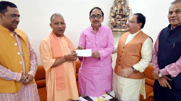 Yogi Adityanath handing over cheque of Rs 2.51 lakh to UP BJP chief Mahendra Nath Pandey in Lucknow on Monday.(HT) Yogi Adityanath handing over cheque of Rs 2.51 lakh to UP BJP chief Mahendra Nath Pandey in Lucknow on Monday.(HT)