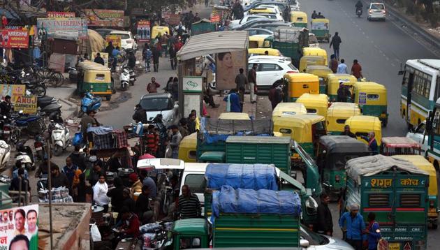 Illegal parking on the footpath is a common sight at the Gandhi Nagar cloth market in east Delhi (above), and many other such places across Delhi, forcing pedestrians to walk on the road amid traffic.(Sonu Mehta/HT Photo)