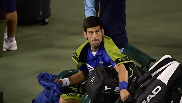 A ball girl holds an umbrella over Novak Djokovic, of Serbia, during a rain break in Djokovic's match against Philipp Kohlschreiber, of Germany, at the BNP Paribas Open tennis tournament Monday, March 11, 2019, in Indian Wells(AP)