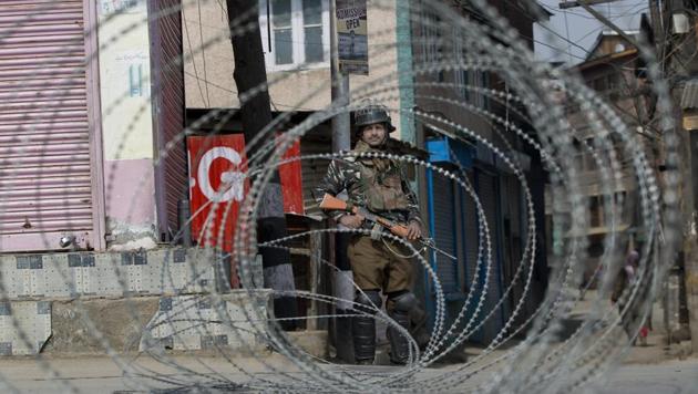 A soldier is seen through barbed wire as he stands guard during security lockdown in Srinagar.(AP File Photo/Representative image)