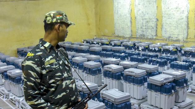 A para-military jawan guards stands guard at a facility where EVMs have been stored.(PTI)