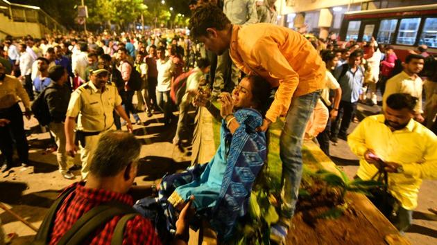 An injured woman is helped at the site of a collapsed footbridge outside the Chhatrapati Shivaji Terminus railway station in Mumbai on Thursday.(REUTERS)