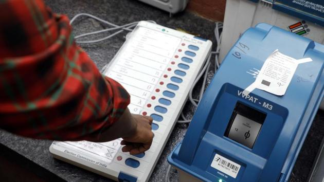 An election commission official gives a demonstration of how to use an EVM(Rahul Raut/HT PHOTO)