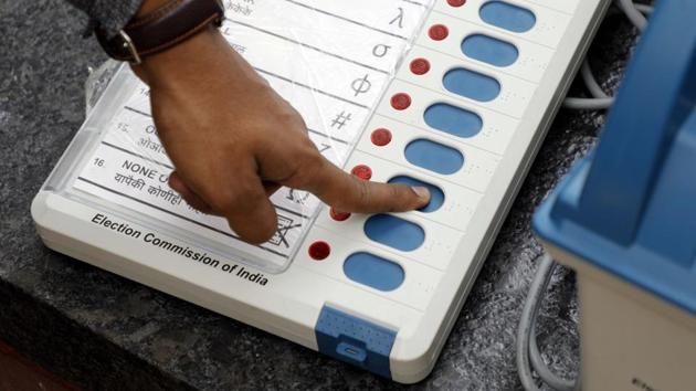 An election commission official gives a demonstration of how to use an EVM.(Rahul Raut/HT PHOTO)