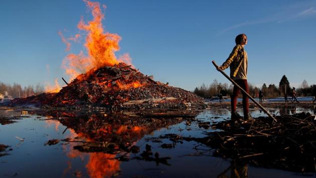 Young woman stands in front of a burning tower made of wooden pallets during celebrations of Maslenitsa, a pagan holiday, marking the end of the winter in the village of Nikola Lenivets in Kaluga region, Russia. (Maxim Shemetov / REUTERS) Young woman stands in front of a burning tower made of wooden pallets during celebrations of Maslenitsa, a pagan holiday, marking the end of the winter in the village of Nikola Lenivets in Kaluga region, Russia. (Maxim Shemetov / REUTERS)