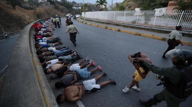 People detained by security forces lie on the street after looting broke out during an ongoing blackout in Caracas, Venezuela. (Ivan Alvarado / REUTERS) People detained by security forces lie on the street after looting broke out during an ongoing blackout in Caracas, Venezuela. (Ivan Alvarado / REUTERS)