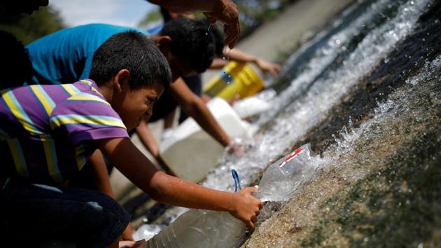 People collect water released through a sewage drain that feeds into the Guaire River, which carries most of the city's wastewater, in Caracas, Venezuela. (Carlos Garcia Rawlins / REUTERS) People collect water released through a sewage drain that feeds into the Guaire River, which carries most of the city's wastewater, in Caracas, Venezuela. (Carlos Garcia Rawlins / REUTERS)