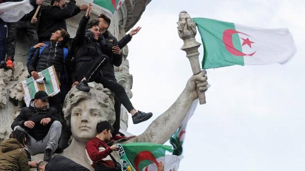 Protestors hold Algerian flags as they attend a demonstration against Algerian President Abdelaziz Bouteflika on the Place de la Republique, in Paris, France. Bouteflika finally relented and resolved to not run for a fifth consecutive term. (Philippe Wojazer / REUTERS) Protestors hold Algerian flags as they attend a demonstration against Algerian President Abdelaziz Bouteflika on the Place de la Republique, in Paris, France. Bouteflika finally relented and resolved to not run for a fifth consecutive term. (Philippe Wojazer / REUTERS)
