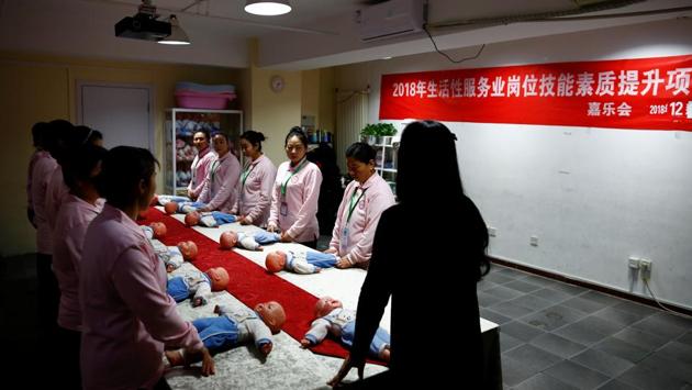 Students at Ayi University, a training program for domestic helpers, practice on baby dolls during a course teaching childcare in Beijing, China. (Thomas Peter / REUTERS) Students at Ayi University, a training program for domestic helpers, practice on baby dolls during a course teaching childcare in Beijing, China. (Thomas Peter / REUTERS)