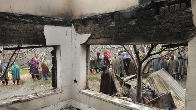 Villagers gather near a residential house which was damaged during a gunfight between militants and government forces at Pinglish village of Tral, 40 km south of Srinagar, Jammu and Kashmir. (Waseem Andrabi / HT Photo) 