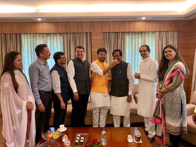 Shiv Sena minister Arjun Khotkar and BJP state president Raosaheb Danve, flanked by chief minister Devendra Fadnavis and Sena chief Uddhav Thackeray, exchange sweets after both decided to end feud . Sena leader Sanjay Raut (next to CM), BJP minister Pankaja Munde (extreme right) were also present.(HT)