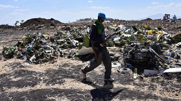 An Oromo man hired to assist forensic investigators walks by a pile of twisted airplane debris at the crash site of an Ethiopian airways operated Boeing 737 MAX aircraft on March 16, 2019 at Hama Quntushele village near Bishoftu in Oromia region.(AFP Photo)