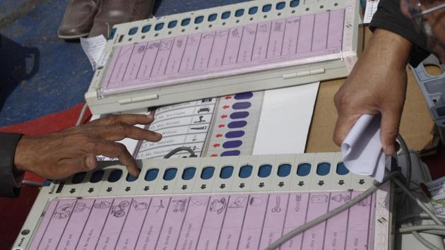 Polling officers check electronic voting machines at an EVM distribution centre.(Burhaan Kinu/HT Photo)