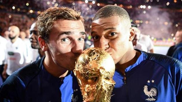 France's Antoine Griezmann (L) and Kylian Mbappe kiss the 2018 World Cup trophy.(AFP) France's Antoine Griezmann (L) and Kylian Mbappe kiss the 2018 World Cup trophy.(AFP)