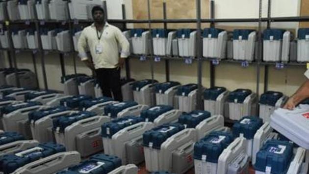 Polling staff check Electronic Voting Machines inside a strong room.(Arijit Sen/HT Photo)