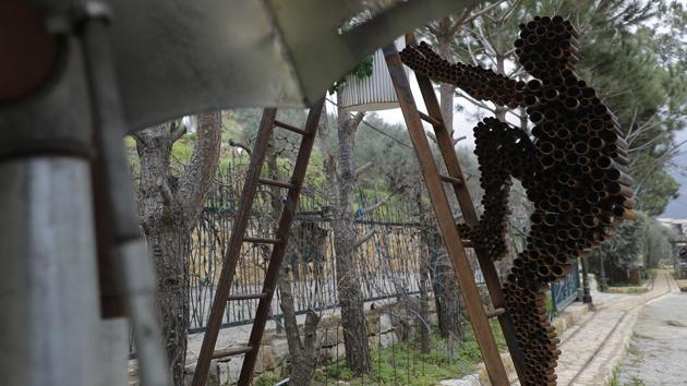 A sculpture depicts a man made out of artillery casings climbing a ladder. Nassar was forced to flee Lebanon during the civil war, and his grandmother was killed in the violence. But she and other characters of the artist’s past live on, displayed in the nooks and crannies of his garden in the village of Remhala. (Joseph Eid / AFP) A sculpture depicts a man made out of artillery casings climbing a ladder. Nassar was forced to flee Lebanon during the civil war, and his grandmother was killed in the violence. But she and other characters of the artist’s past live on, displayed in the nooks and crannies of his garden in the village of Remhala. (Joseph Eid / AFP)