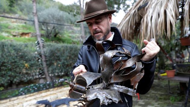 Lebanese Artist Charles Nassar inspects his sculptures in the village of Remhala. Artist Charles Nassar has been transforming their dark, wrangled remains into sculptures to celebrate tradition and memory. “I hate shrapnel, but I also love it at the same time,” said the 54-year-old with a neat salt-and-pepper beard, in a garden south of Beirut. (Joseph Eid / AFP) Lebanese Artist Charles Nassar inspects his sculptures in the village of Remhala. Artist Charles Nassar has been transforming their dark, wrangled remains into sculptures to celebrate tradition and memory. “I hate shrapnel, but I also love it at the same time,” said the 54-year-old with a neat salt-and-pepper beard, in a garden south of Beirut. (Joseph Eid / AFP)