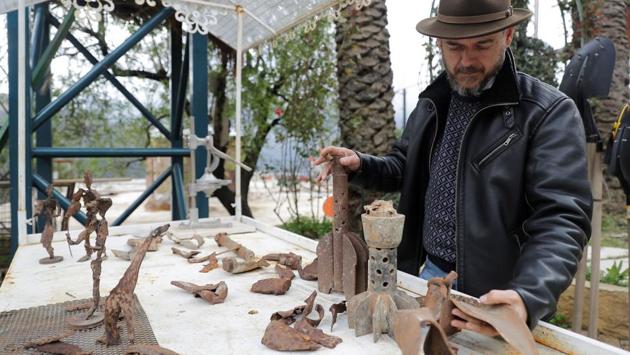 Charles Nassar inspects his sculptures and collected pieces of shrapnel for his projects. “The shrapnel takes on shapes in my mind... They guide me to what I should do with them,” said the artist. Nassar first created his metal sculptures in Beirut, but after the war he decided to display them on land he owned in Remhala. (Joseph Eid / AFP) Charles Nassar inspects his sculptures and collected pieces of shrapnel for his projects. “The shrapnel takes on shapes in my mind... They guide me to what I should do with them,” said the artist. Nassar first created his metal sculptures in Beirut, but after the war he decided to display them on land he owned in Remhala. (Joseph Eid / AFP)