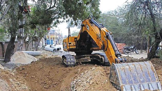 Digging work was being carried out by MCG’s contractor to lay a sewer line from Shankar Vihar to the sewage treatment plant at Dhanvapur. (HT Photo) Digging work was being carried out by MCG’s contractor to lay a sewer line from Shankar Vihar to the sewage treatment plant at Dhanvapur. (HT Photo)