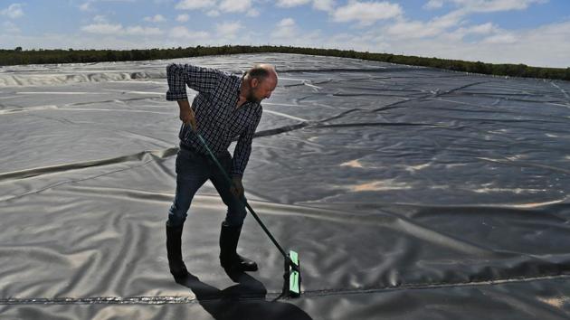 Mike Buckby from the Cape Grim Water Company cleans a system of tarps, sluices and reservoirs. Buckby, a “rain farmer” from the Cape Grim Water Company, has taken things to another level, harvesting water falling “from Earth’s purest skies. Most waters of the world are spring waters,” he explains as he looks out over a system of tarps, sluices and reservoirs set back from the coast. (William West / AFP) Mike Buckby from the Cape Grim Water Company cleans a system of tarps, sluices and reservoirs. Buckby, a “rain farmer” from the Cape Grim Water Company, has taken things to another level, harvesting water falling “from Earth’s purest skies. Most waters of the world are spring waters,” he explains as he looks out over a system of tarps, sluices and reservoirs set back from the coast. (William West / AFP)