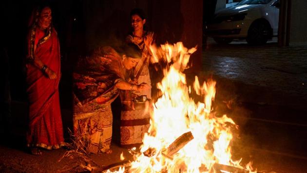 Holika Dahan also Kamudu pyre is celebrated by burning Holika, the devil. For many traditions in Hinduism, Holi celebrates the killing of Holika by Vishnu in order to save Prahlad, a devotee of God Vishnu. Residents at Wakad take blessing from Holika on the eve of  Holi on Wednesday.  (Milind Saurkar/HT Photo) 
