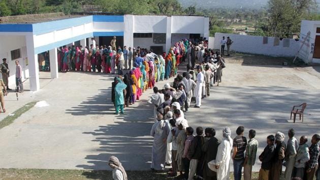 Voters stand in a queue at a polling station in Jammu. (Nitin Kanotra / HT Photo)