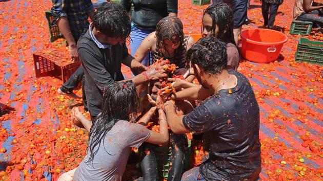 People could be seen playing Holi in different ways at different places, here seen a group of people playing with tomato pulp as part of the celebrations in Ahmedabad. (Amit Dave / REUTERS) People could be seen playing Holi in different ways at different places, here seen a group of people playing with tomato pulp as part of the celebrations in Ahmedabad. (Amit Dave / REUTERS)