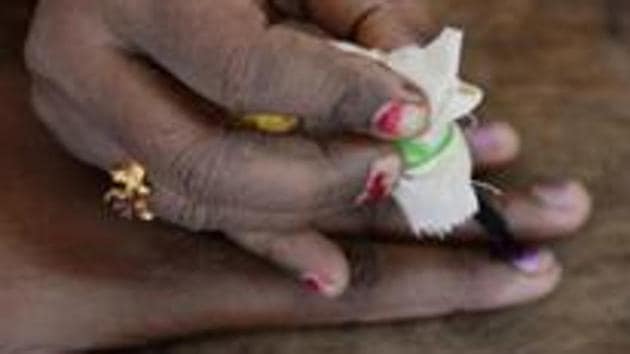 An Indian election official puts indeliable ink on the finger of a voter in Karnataka.(AFP)