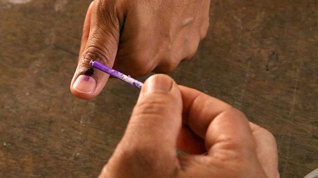 A polling officer marks the finger of a voter with indelible ink at a polling station.(AP Photo) A polling officer marks the finger of a voter with indelible ink at a polling station.(AP Photo)
