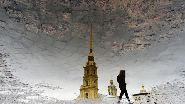 The silhouette of a woman is reflected in a puddle as she crosses a square in front of the Peter and Paul Cathedral in Saint Petersburg, Russia. (Olga Maltseva / AFP) The silhouette of a woman is reflected in a puddle as she crosses a square in front of the Peter and Paul Cathedral in Saint Petersburg, Russia. (Olga Maltseva / AFP)