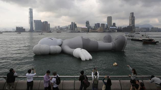 Fans take pictures of the ‘KAWS:HOLIDAY’ ‘Companion’, at the waterfront of the Victoria Harbour after the opening ceremony for its exhibition in Hong Kong. The 37-meter long ‘KAWS:HOLIDAY’ ‘Companion’, is an inflatable sculpture created by US artist and designer Brian Donnelly, known professionally as Kaws. (Kin Cheung / AP) Fans take pictures of the ‘KAWS:HOLIDAY’ ‘Companion’, at the waterfront of the Victoria Harbour after the opening ceremony for its exhibition in Hong Kong. The 37-meter long ‘KAWS:HOLIDAY’ ‘Companion’, is an inflatable sculpture created by US artist and designer Brian Donnelly, known professionally as Kaws. (Kin Cheung / AP)