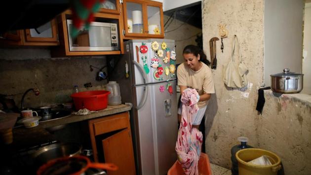 Jenny Montana, 38, washes a blanket at home in the apartment block. Montana, currently unemployed, lives with her daughter on the 9th floor. She said that she has to carry containers filled with 20 litres of water. “I remember once I had to carry up five containers in a day.” (Carlos Garcia Rawlins / REUTERS) 