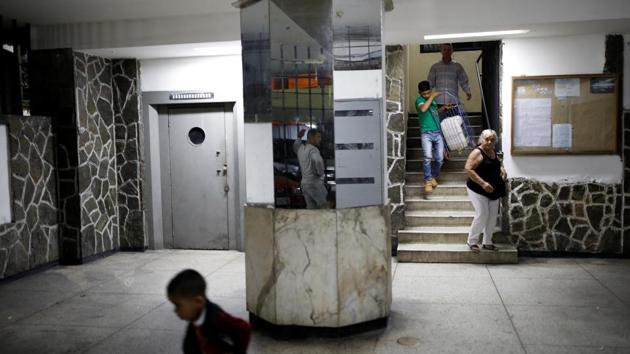 Residents walk down stairs carrying a container to collect water. Since the nationwide blackout, the worst in decades, lines of people queuing to fill up water flowing from the Avila have multiplied, despite warnings that the water was not fit for consumption and could contain bacteria and parasites. (Carlos Garcia Rawlins / REUTERS) 
