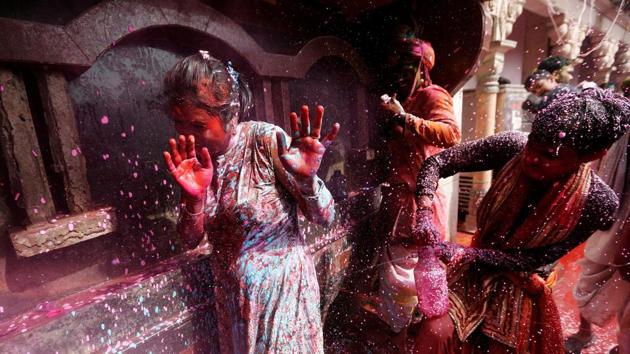 A boy sprays coloured water on a girl during Holi inside a temple in Nandgaon village, in the state of Uttar Pradesh. (Adnan Abidi / REUTERS) 